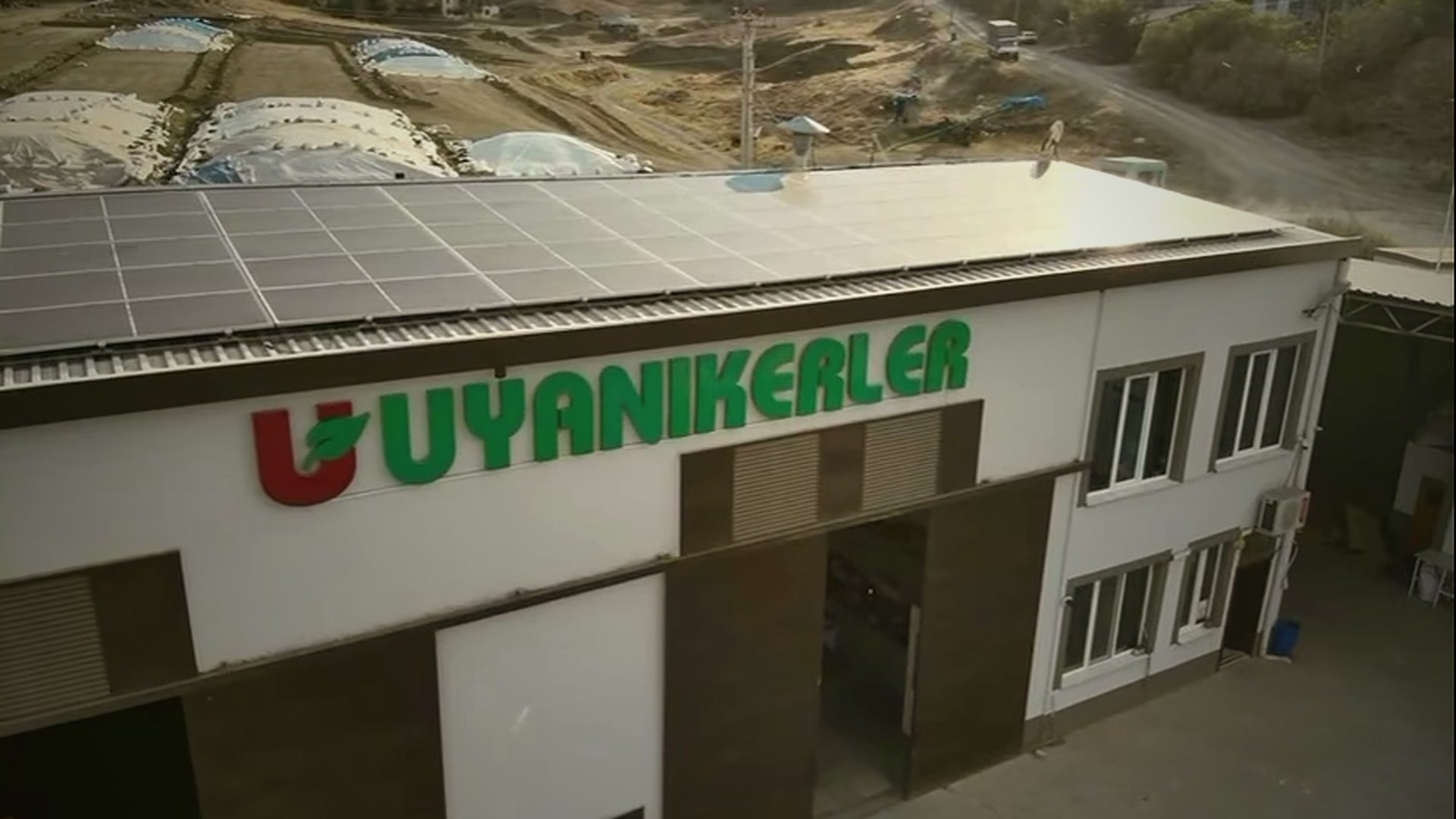 Uyanıkerler logolu tesis binası ve çatısındaki güneş panelleri
